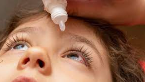 an image of boy having atropine eye drop